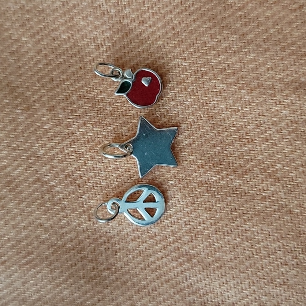 A trio of sterling silver pendants.